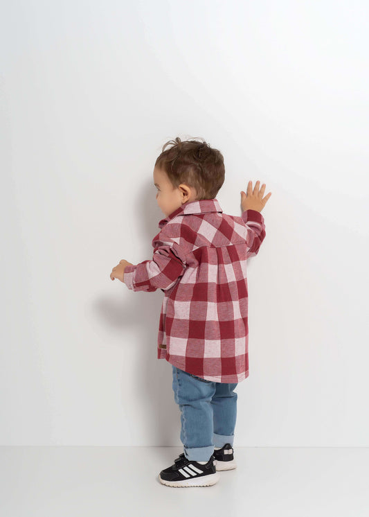 Çocuğun arka tarafı görünümdeki ekoseli gömlek ve mavi pantolon kombinasyonu.