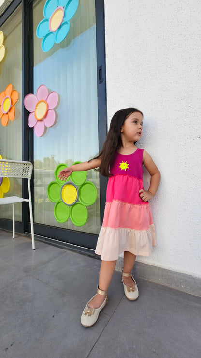 Gypsy Dress 🌞 worn by a girl, showcasing vibrant colors and playful design against a flower-decorated background.