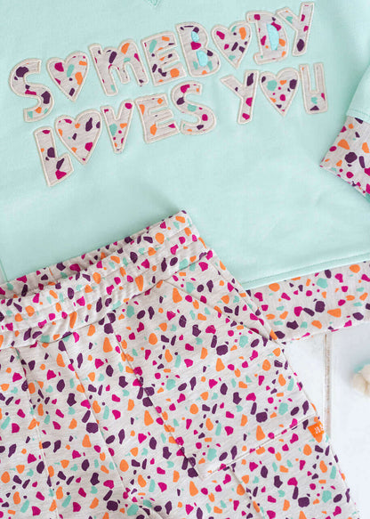 Mint yeşili sloganlı sweatshirt ve şort yakın plan görüntüsü.