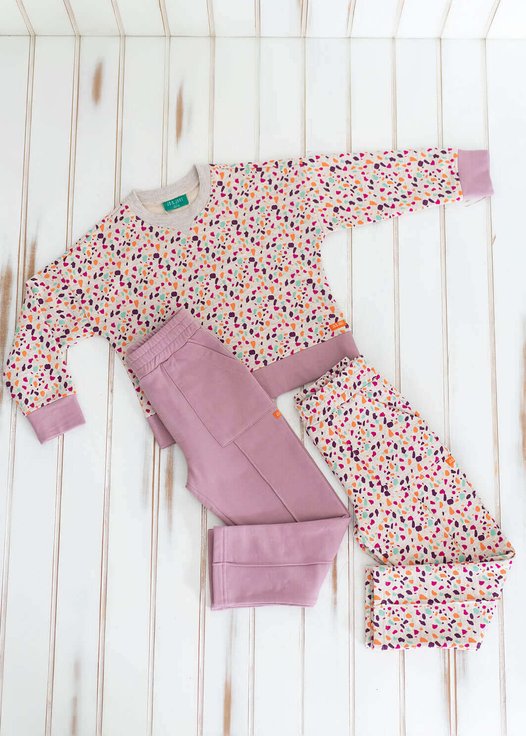 Pudra renkli çocuk pantolonu ve desenli sweatshirt, çocuklar için rahat ve şık kombin.