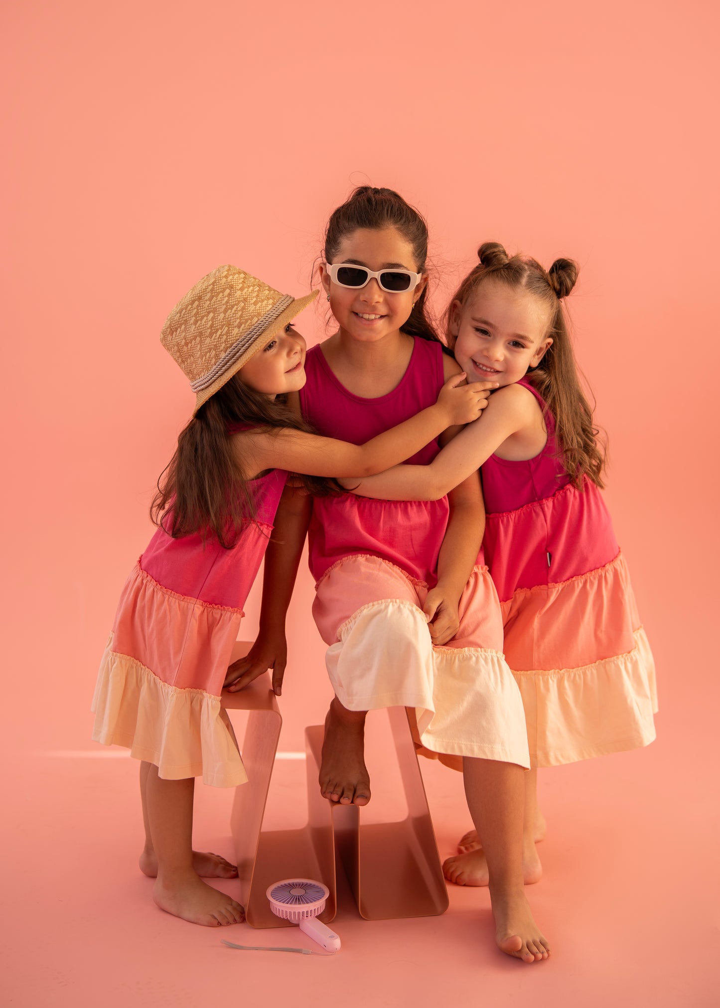 Three girls wearing colorful gypsy dresses, enjoying summer vibes, showcasing the Gypsy Dress 🌞 in a playful setting.